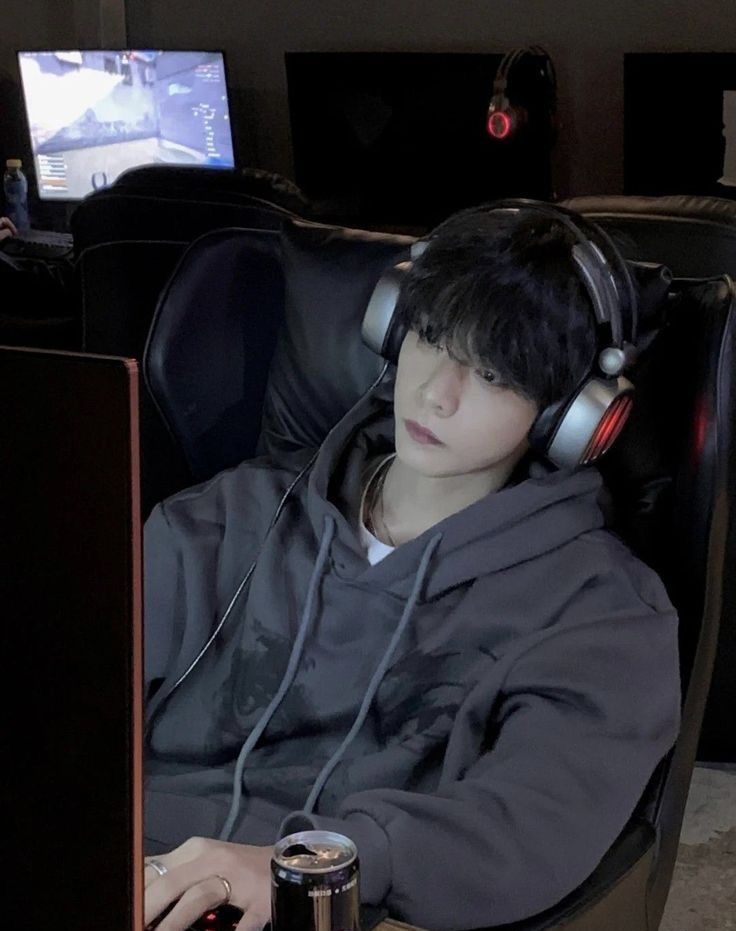 a man wearing headphones sitting in front of a computer