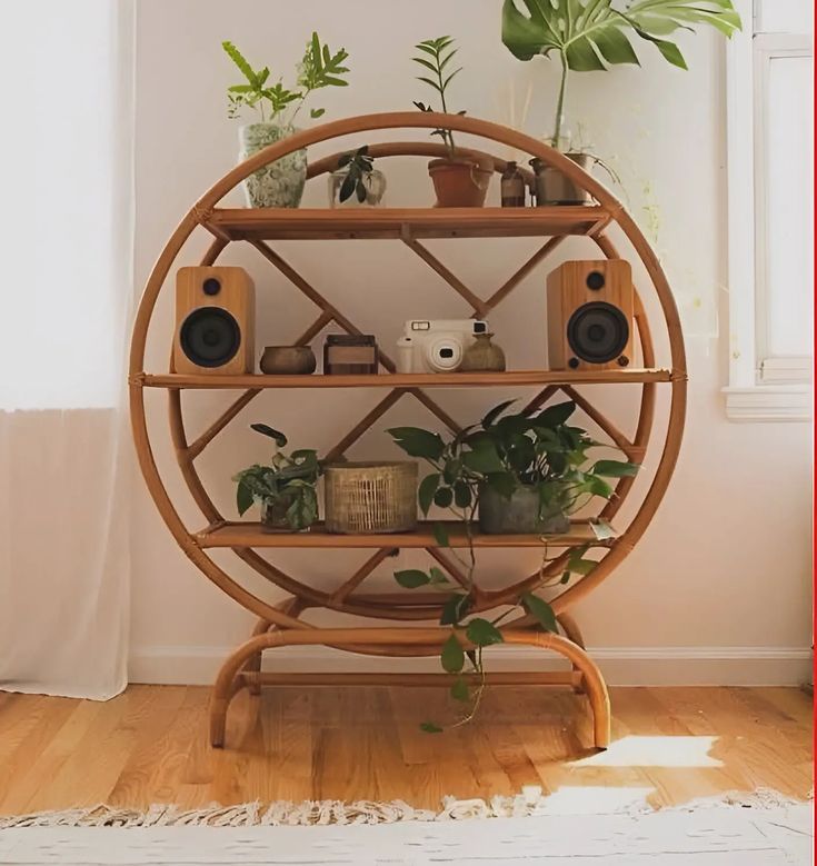 a wooden shelf with plants and speakers on it