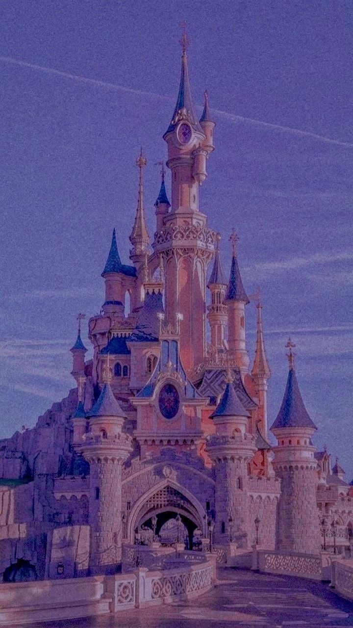 a castle with turrets and towers is lit up in the night sky at disneyland's magic kingdom