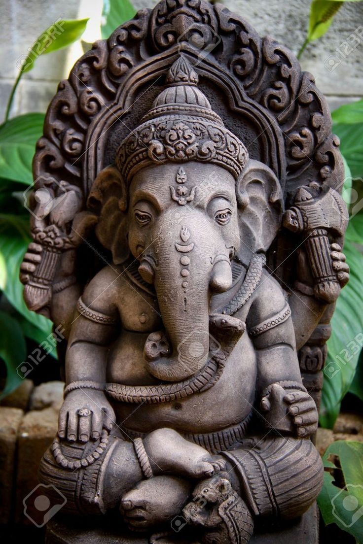 an elephant statue sitting in front of some plants