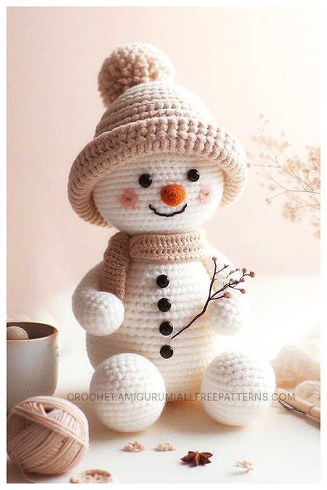 a crocheted snowman sitting on top of a table next to balls of yarn