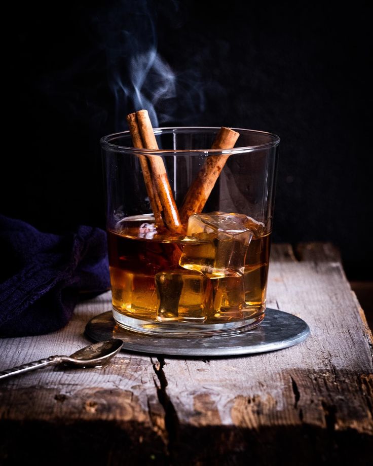 a glass filled with liquid and cinnamon sticks