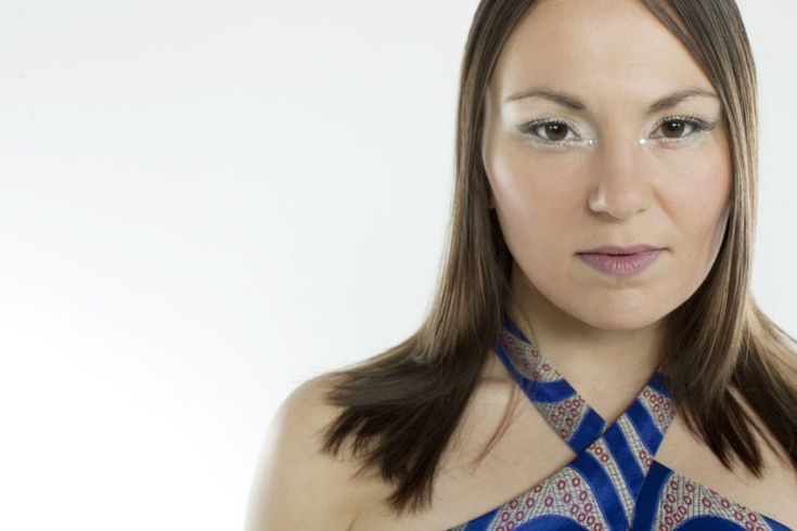 a woman wearing a blue and white neck tie looking at the camera with an intense look on her face