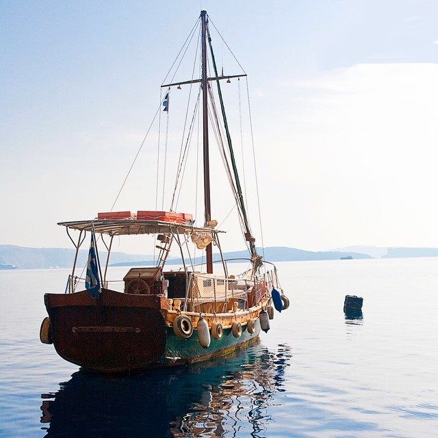 an old boat is sitting in the middle of the water with no people on it