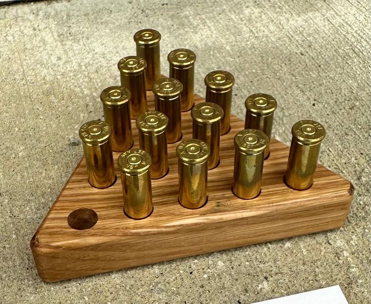 357 Magnum Brass Casing Peg Game A perfect gift for the outdoorsman in your family! Hand crafted from solid oak with a polyurethane finish makes this product last forever  Size is approximately 4 1/4"X4 1/2" and 3/4 inches thick  Each game comes with one board and 14 used .357 magnum brass casings Check out or shop for different size caliber games! Triangle Peg Game, Peg Game, Executive Office Decor, Rustic Office Decor, Bullet Crafts, Rustic Office, Executive Gifts, Bullet Casing, Man Cave Home Bar