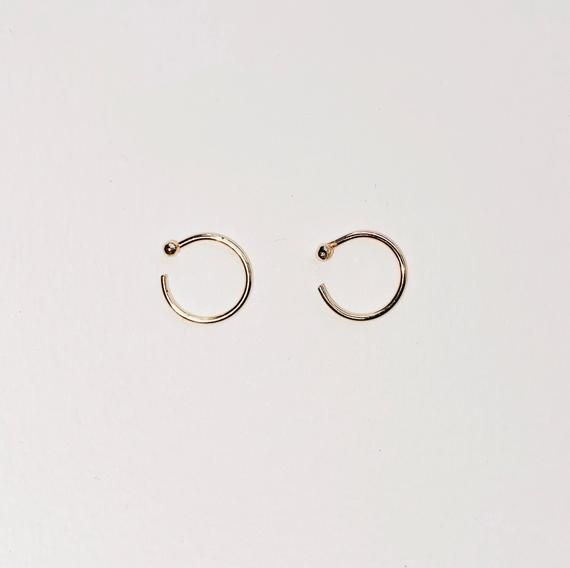 + TINY GOLD HUGGIE +TINY GOLD HUGGIE earrings made in Solid 14k Yellow Gold. Dainty open hoops with balls that hugs your ears. Shiny Yellow Gold hoops that you can wear everyday, literally. An everyday staple and heirloom. Perfect for your earlobes, cartilage or tragus. Wear 1 or a pair.+ 14ky Gold huggie hoops+ Sold as 1 single or pair + 2mm ball+ Please allow 3-5 business days to ship out. Minimalist Recycled Gold Huggie Earrings, Minimalist 14k Gold-filled Cartilage Earrings, Everyday Minimalist 14k Gold Ear Cuff, Minimalist 14k Gold Huggie Ear Cuff, Minimalist 14k Gold Huggie Earrings, Gold Minimalist Tarnish-resistant Cartilage Earrings, Tiny Minimalist Small Hoop Piercings, Everyday Yellow Gold Nickel-free Piercings, Everyday Nickel-free Yellow Gold Piercings