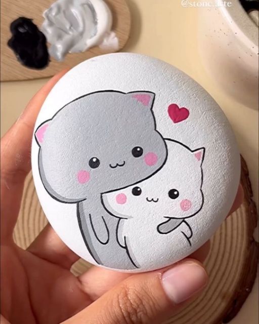 a person holding an egg with two cats on it