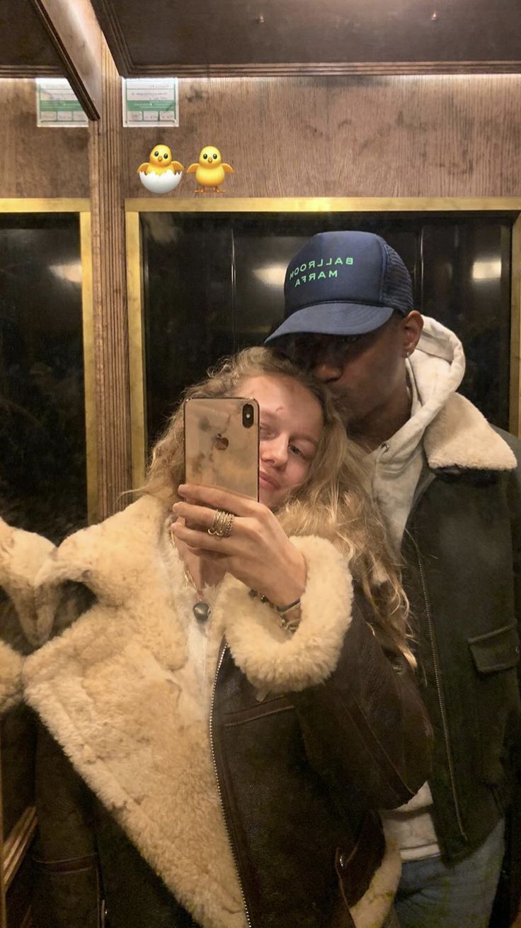 a man and woman taking a selfie on the subway