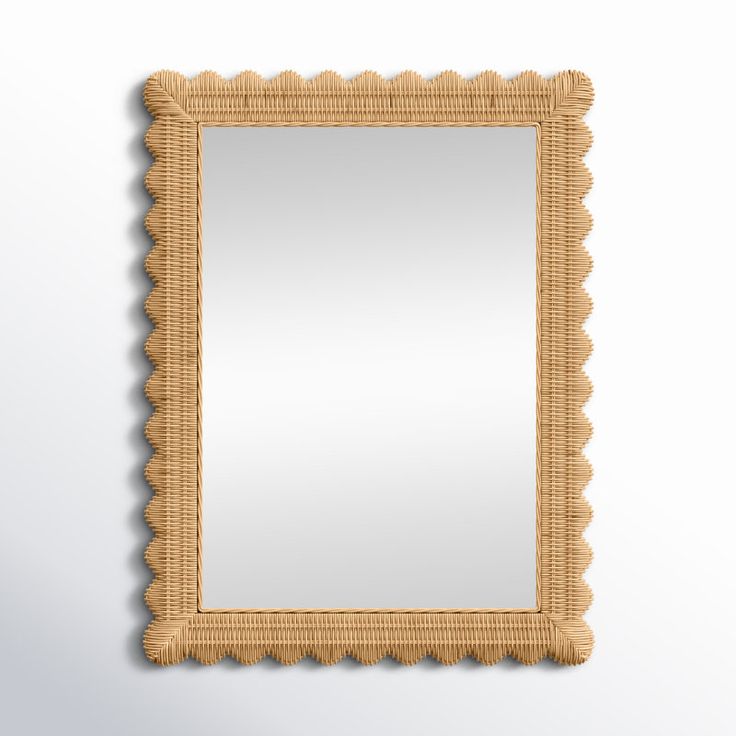 a wooden frame with scalloped edges and a mirror on the wall above it