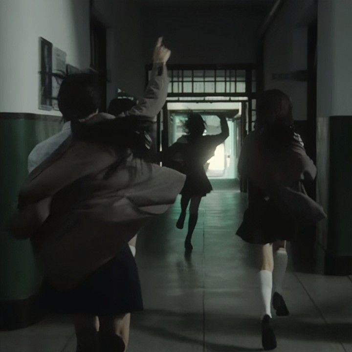 two girls are running down the hallway with their arms in the air and one girl is holding her hand up