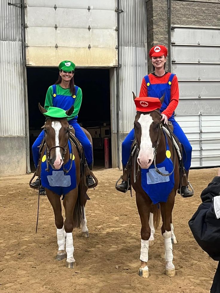 two people are riding horses in front of a building and one person is holding a camera