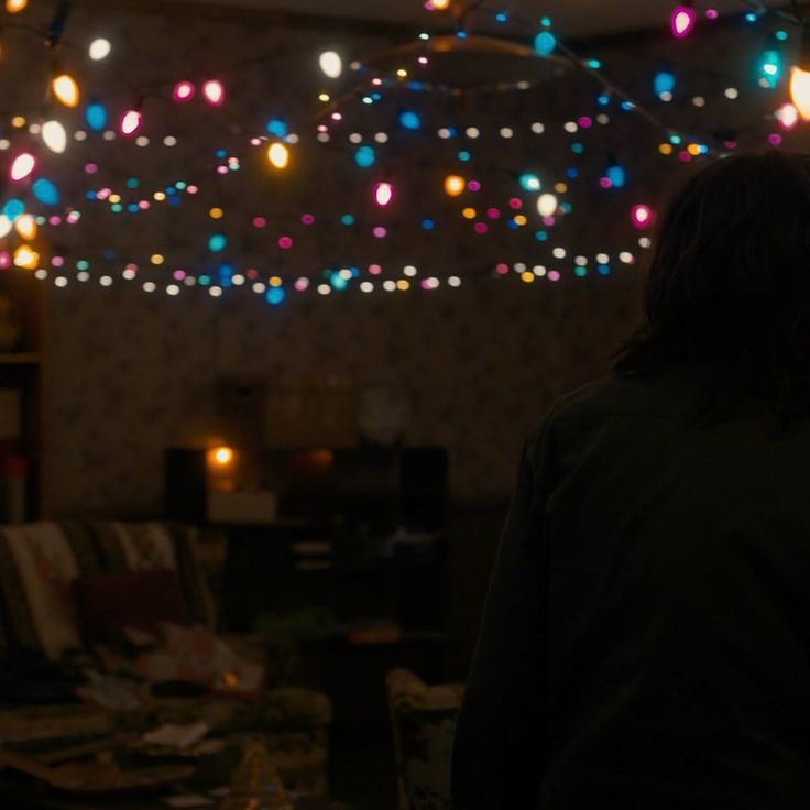 a person standing in front of a living room filled with lights