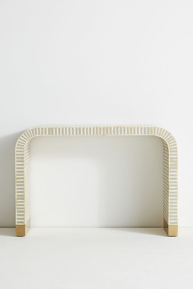 a white and gold shelf against a white wall with no one in it or someone else