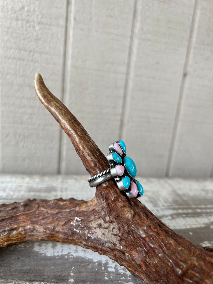 The Wrenley Ring is a unique addition to any collection, crafted by Navajo artisan with sterling silver and featuring Kingman and Pink Conch stones. Its adjustable design and double band with rope border make it the perfect western accessory. Elevate your style with this one-of-a-kind piece. *Matching Earrings Sold Separately 1.5" x 1" Stamped by designer E Richards, Sterling Rope Border, Western Accessories, Silver Jewelry Fashion, Accessories Jewelry Earrings, Wedge Boots, Beauty Gift, Conch, Sterling Ring, Earring Necklace