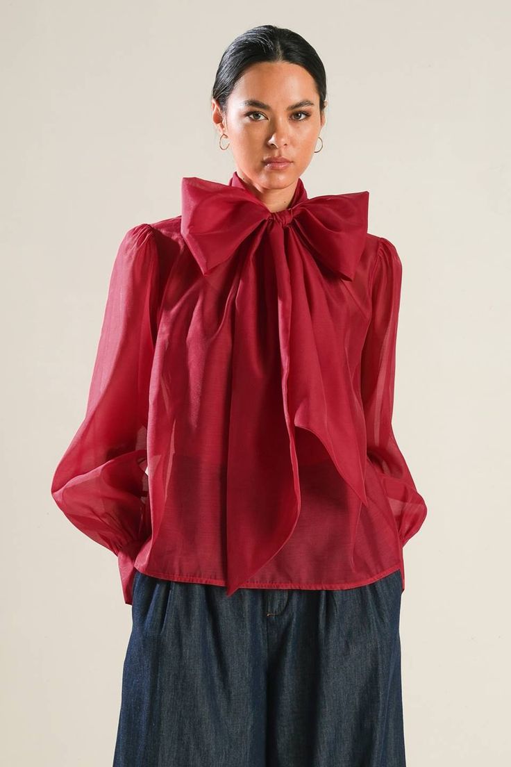 A solid organza top featuring front bow tie, long blouson sleeve with cuff and cami Details: Self : 100% PolyesterLining : 100% Polyester Size & Fit - Model is 5`8" And Wearing Size Small- Measurements Taken From Size Small- Approx. Length: 23.5" Elegant Solid Color Sheer Top, Elegant Sheer Solid Color Top, Feminine Bow Top For Fall, Feminine Long Sleeve Organza Tops, Chic Party Blouse With Bow Tie, Elegant Spring Tops With Detachable Bow, Elegant Tops With Detachable Bow For Spring, Long Sleeve Organza Tops For Party, Organza Long Sleeve Party Tops