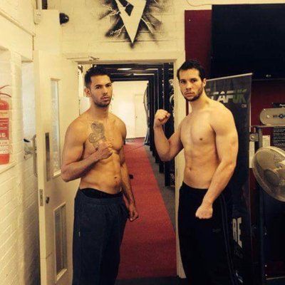 two men standing next to each other in front of a locker with tattoos on their chestes