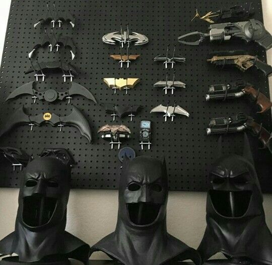 several different types of batman masks hanging on a pegboard in front of a wall