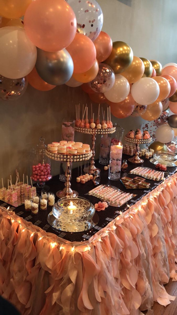 a table topped with lots of desserts and balloons