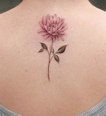 a woman with a pink flower tattoo on her back