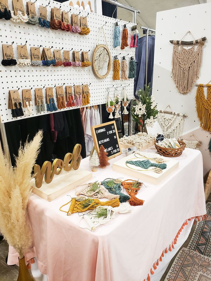 there is a table with many items on it at the store that sells handmade goods