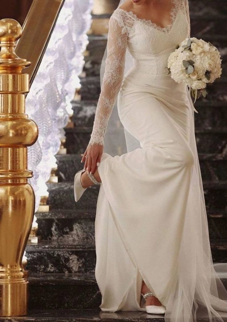 a woman in a wedding dress is walking down the stairs with her hand on her hip