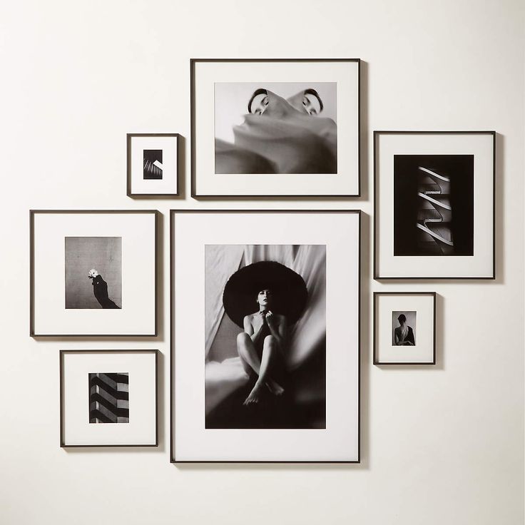 black and white photographs hang on the wall above a woman's head with an umbrella