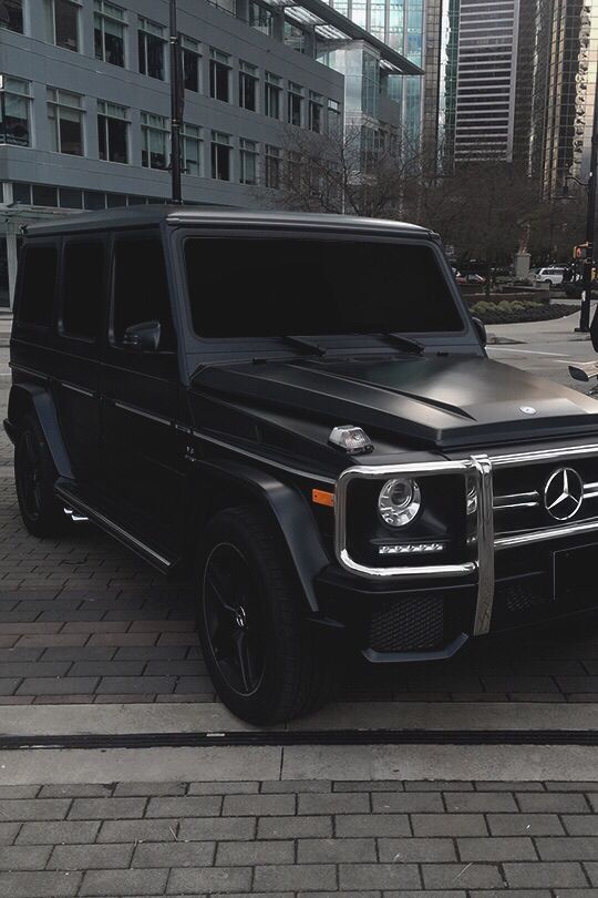 a mercedes g - class is parked on the side of the road