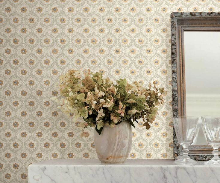 a vase filled with flowers sitting on top of a white table next to a mirror