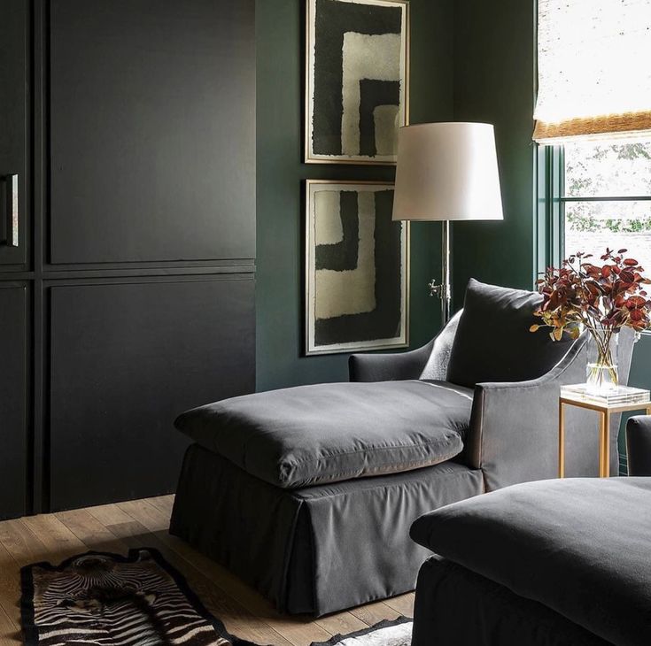 a living room with dark green walls and furniture