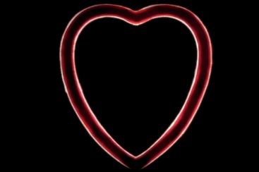 a red neon heart shaped object on a black background