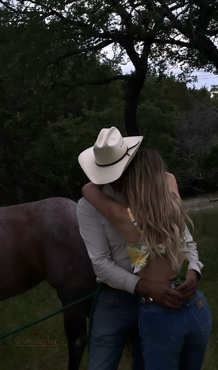 two people hugging each other in front of a horse