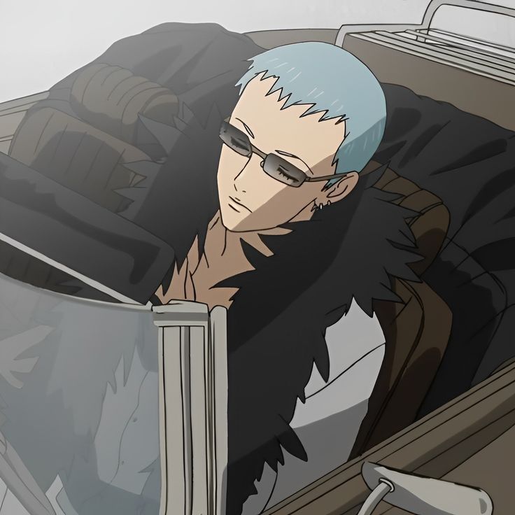 a man with blue hair and glasses sitting in a car