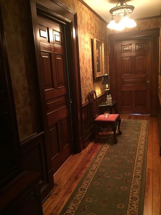 a hallway with wood paneling and an area rug on the floor