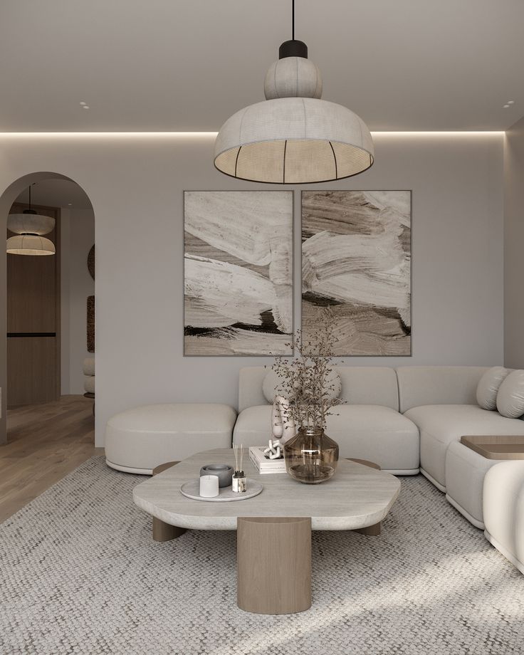 a modern living room with white furniture and artwork on the wall above it, along with an oval coffee table