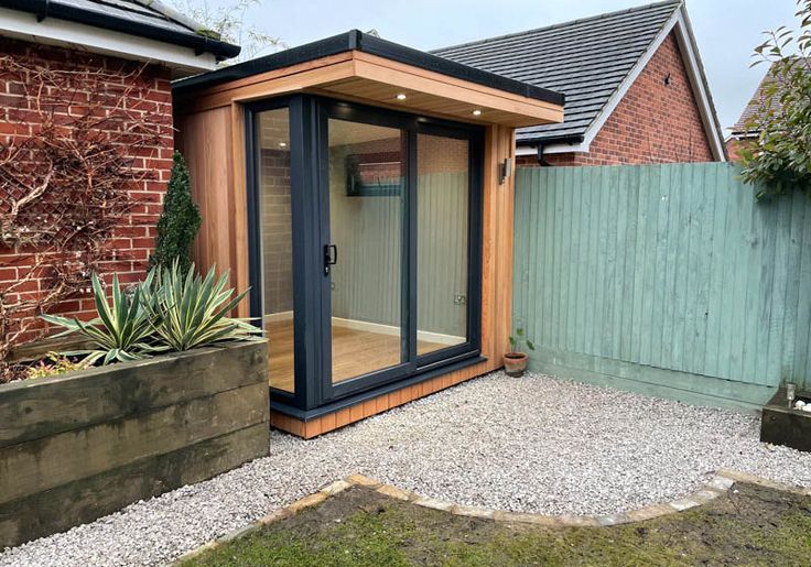 a small garden room in front of a brick building