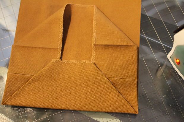 a piece of brown paper sitting on top of a table next to a pair of scissors