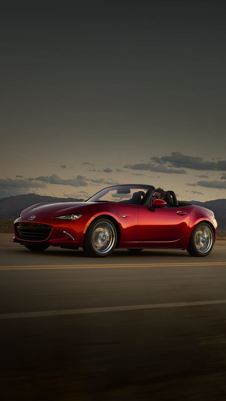 a red sports car driving down the road