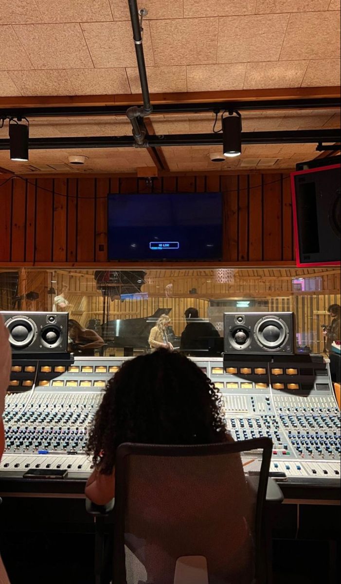 two people sitting in front of sound mixing equipment