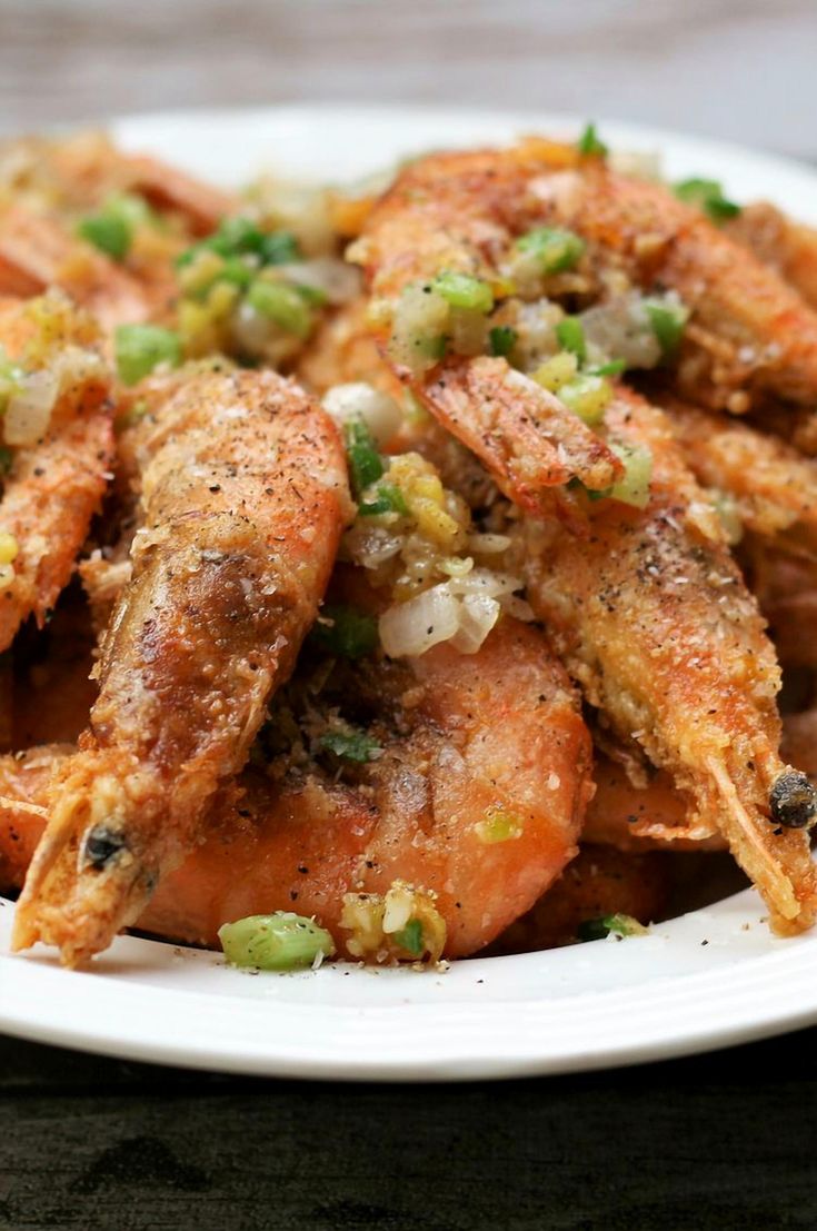 a white plate topped with fried shrimp and vegetables