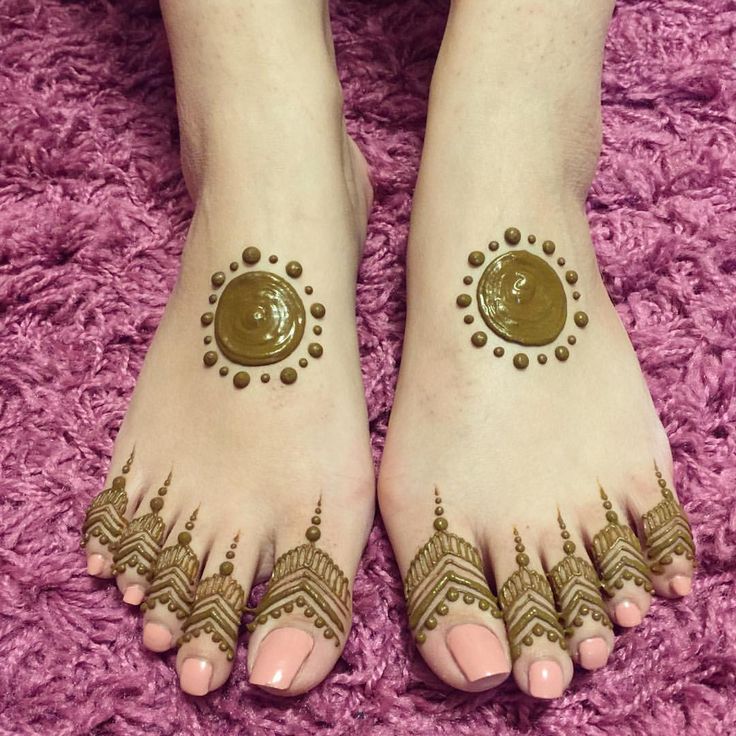 the feet are decorated with henna tattoos and gold dots on their toenails