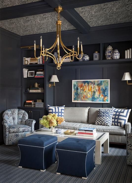 a living room filled with furniture and a chandelier hanging from the ceiling above it