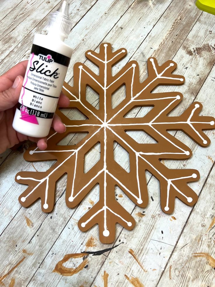 someone is making a snowflake out of wood and glues it onto the floor