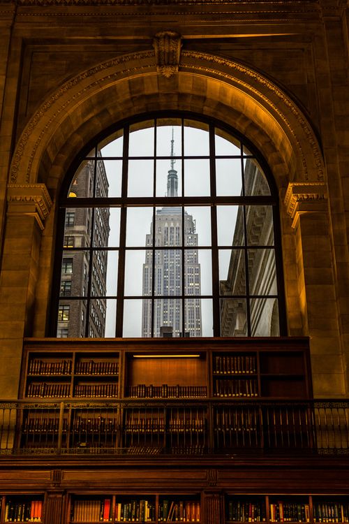 the inside of a library with bookshelves and a large window