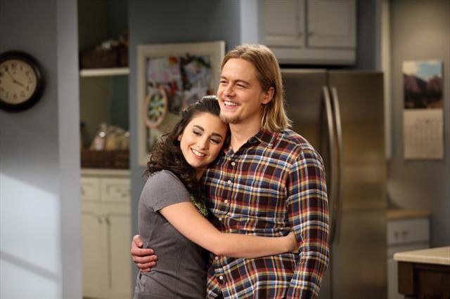 the young couple is hugging in the kitchen