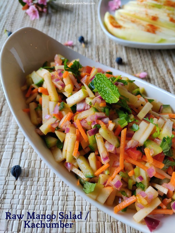 a salad with carrots, celery and other vegetables in a white bowl