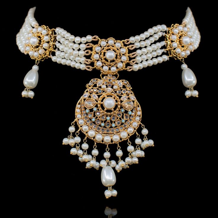 A cohesion of expert artistry and panache rendered into an incredible timeless ensemble! Featuring a delicate and sophisticated set embedded with CZ stones with alluring pearl embellishments infused with serenity. The set includes a necklace and a pair of matching earrings. Approximate earrings length is 3.25". Gold-plated on high-quality brass as base metal. Made by order. Kindly allow 5-7 weeks for the delivery of this item. For custom or urgent requests, please contact support@alacouture.com. Elegant Kundan Jewelry With Intricate Design, Elegant Jeweled Jewelry Sets For Reception, Kundan Jewelry Sets With Elegant Design, Elegant Festive Jewelry Sets With Intricate Design, Elegant Kundan Hand-set Necklace For Reception, Elegant Hand-set Kundan Necklace For Reception, Elegant Hand Set Kundan Necklace For Reception, Elegant Kundan Jewelry For Reception, Elegant Jeweled Bridal Necklace For Reception