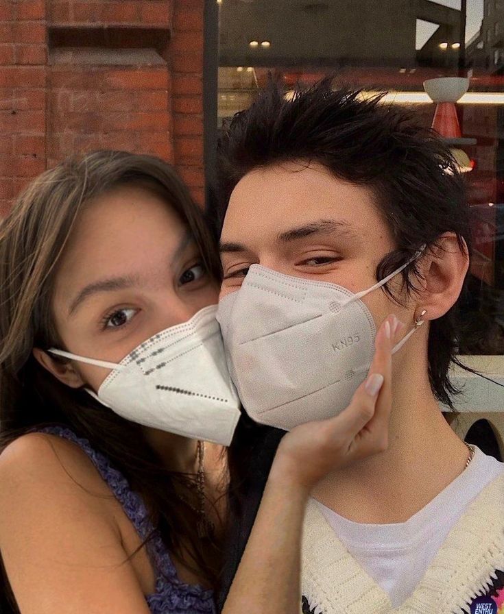 a young man and woman wearing face masks