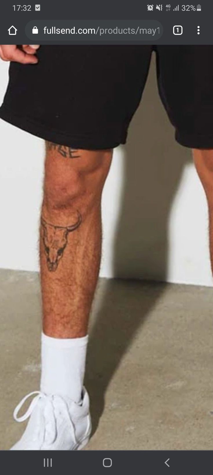 a man's legs with tattoos on them and no shoes in front of him