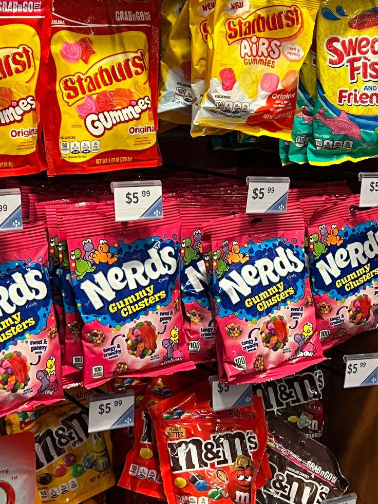 several bags of nerds are on display in a grocery store for $ 5 99