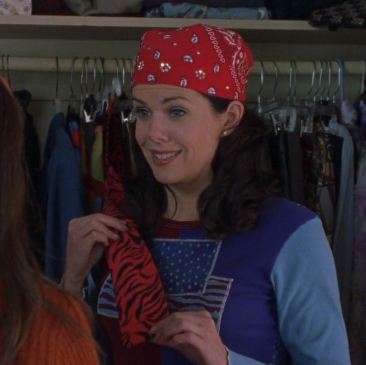 a woman wearing a red bandana standing in front of a closet